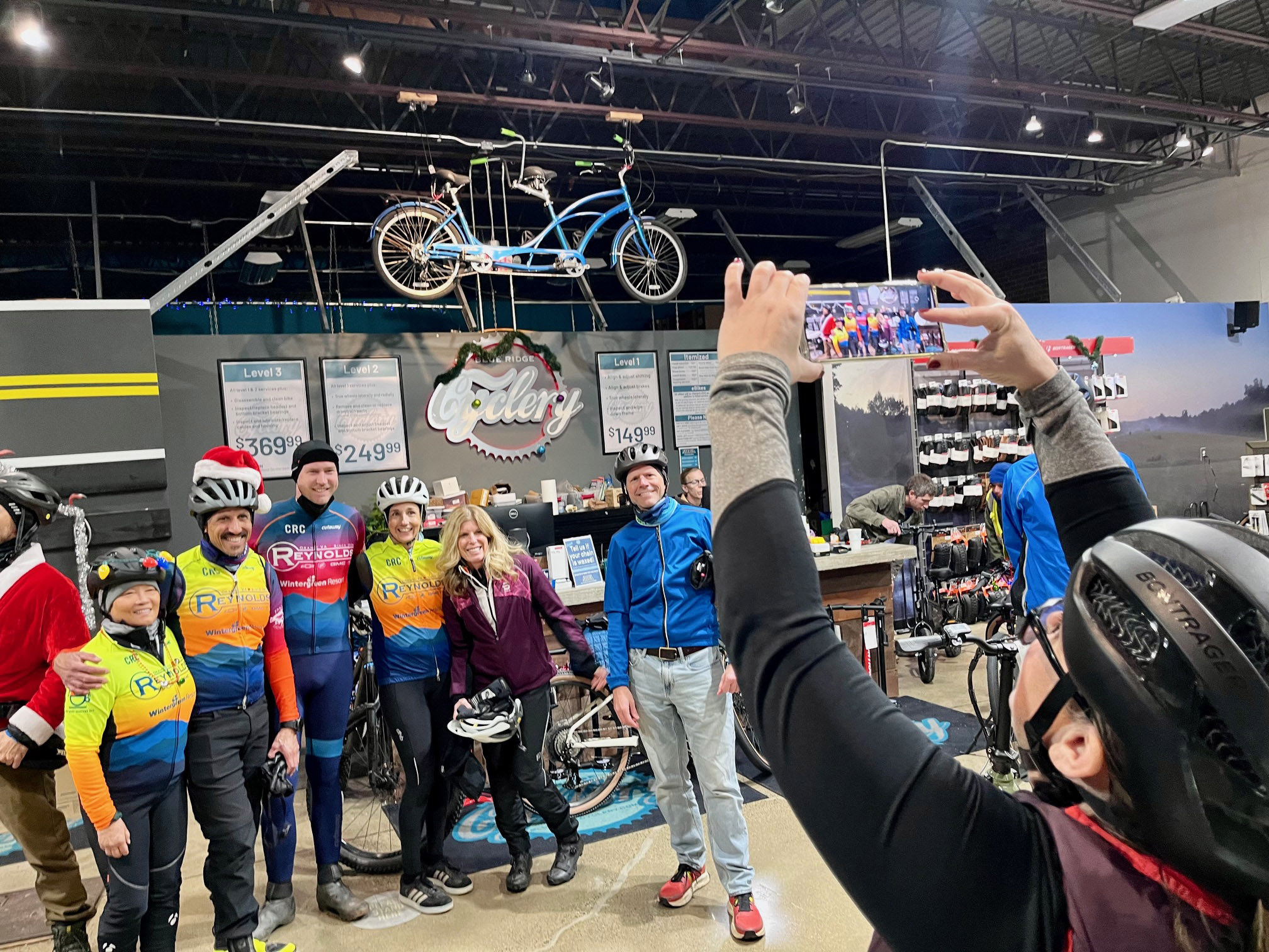 6 people pose for a photo inside a bike shop.