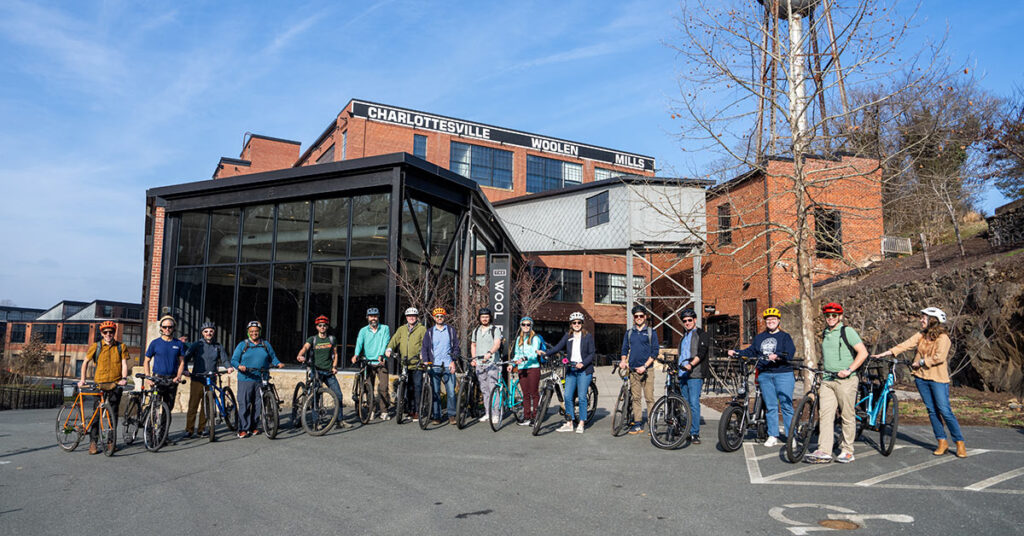Group of cyclists in front of building.
