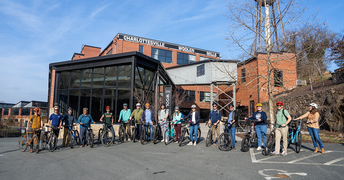 Group of cyclists in front of building.