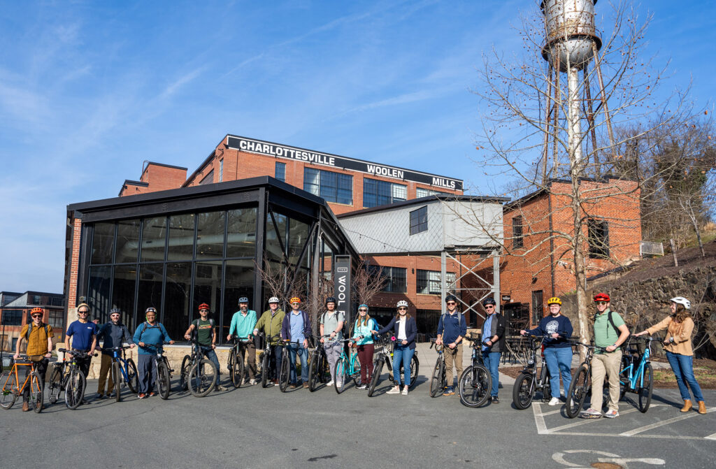 Abut 20 people pose with bikes in front of the Wool Factory in Albemarle County, VA