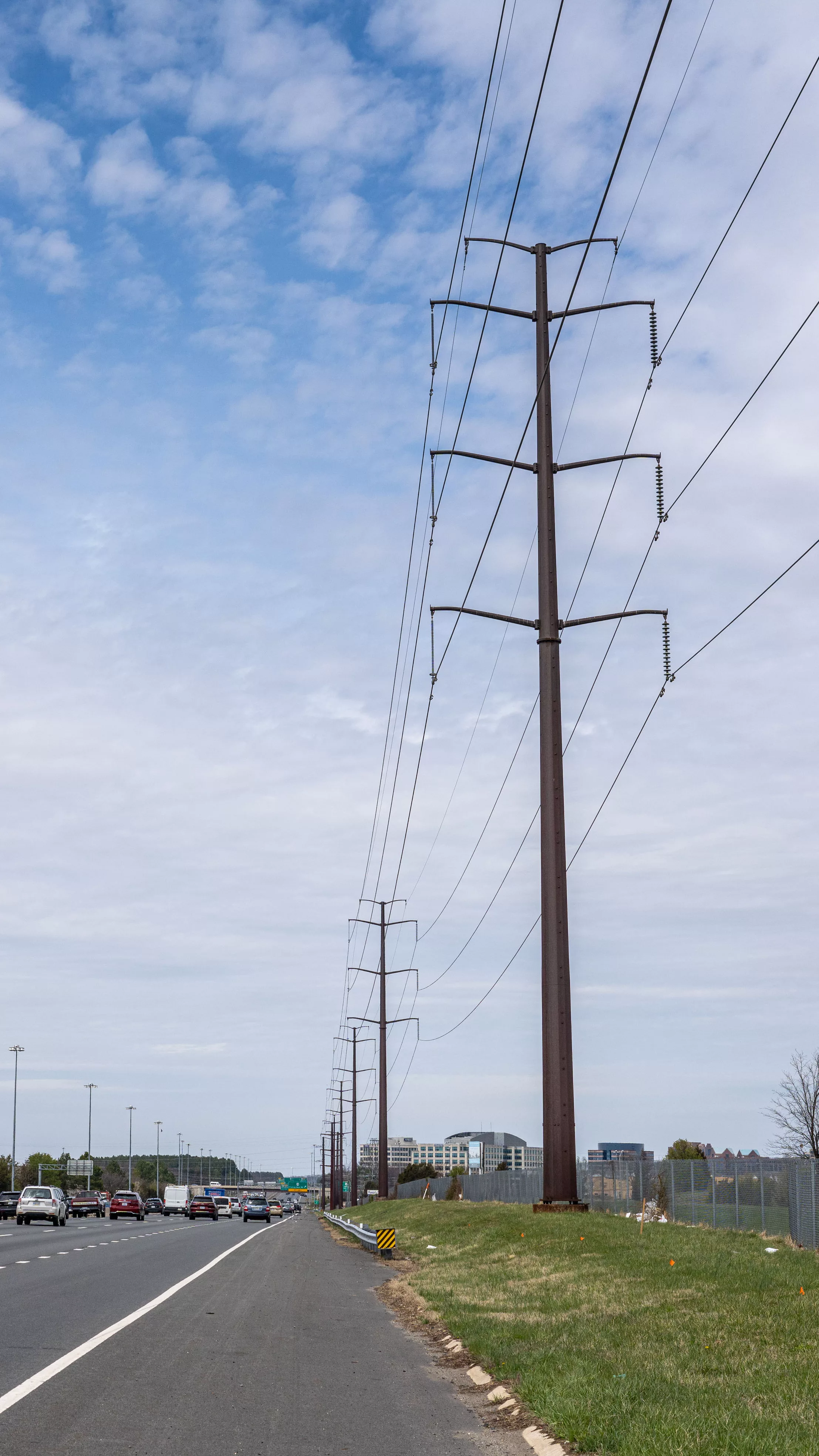 towering transmission lines along a major road