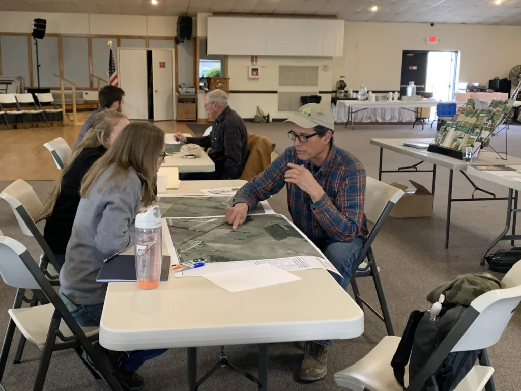 folks point at map on table