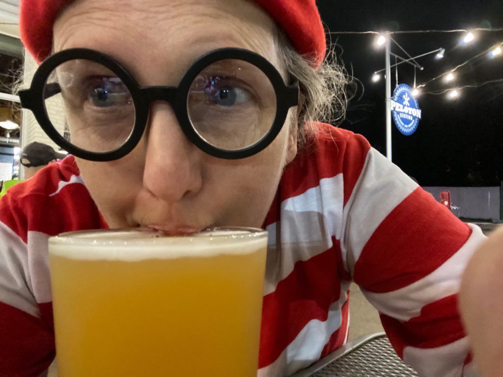 a person dressed as "where's waldo" drinking beer at Peloton Station