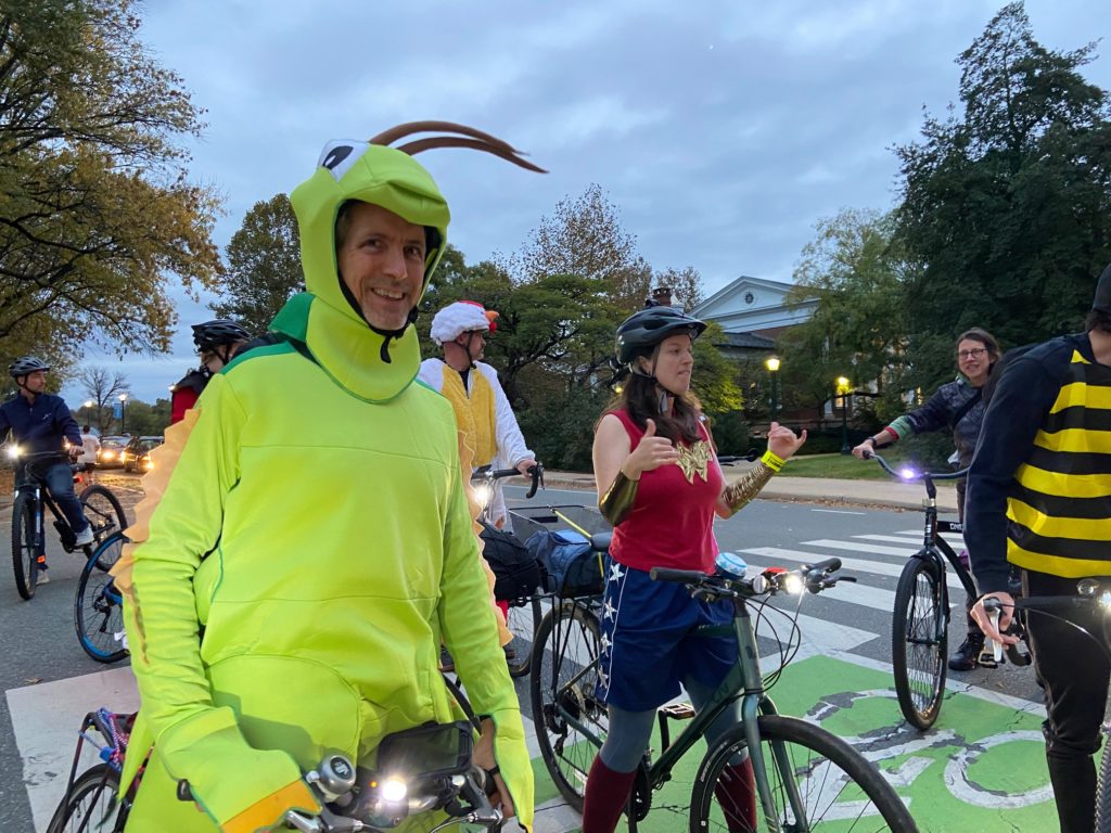 a group of bikers in Halloween costumes, including a grasshopper and a wonder woman