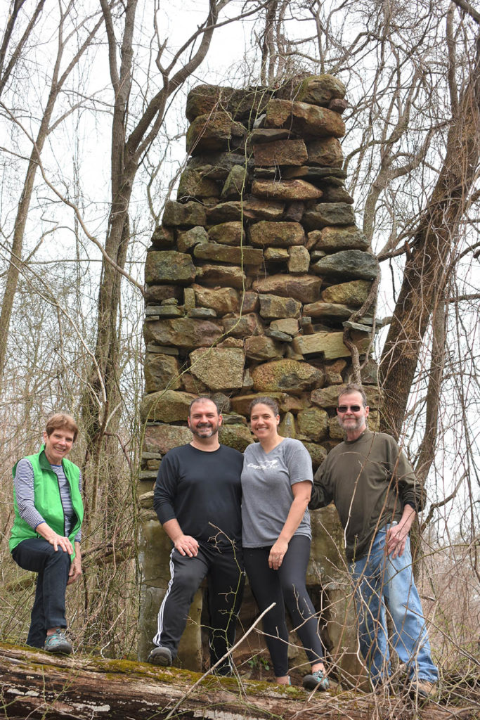 Earl Hawkins and family stand in front of old chimney