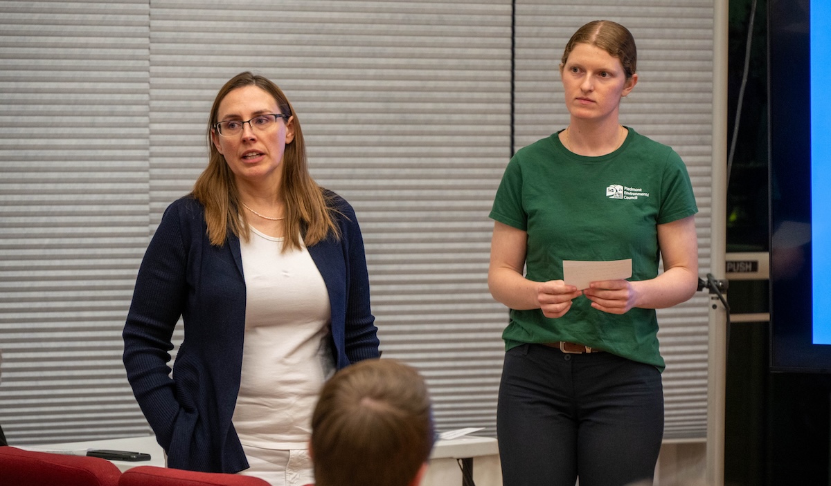 Two women address a seated audience.