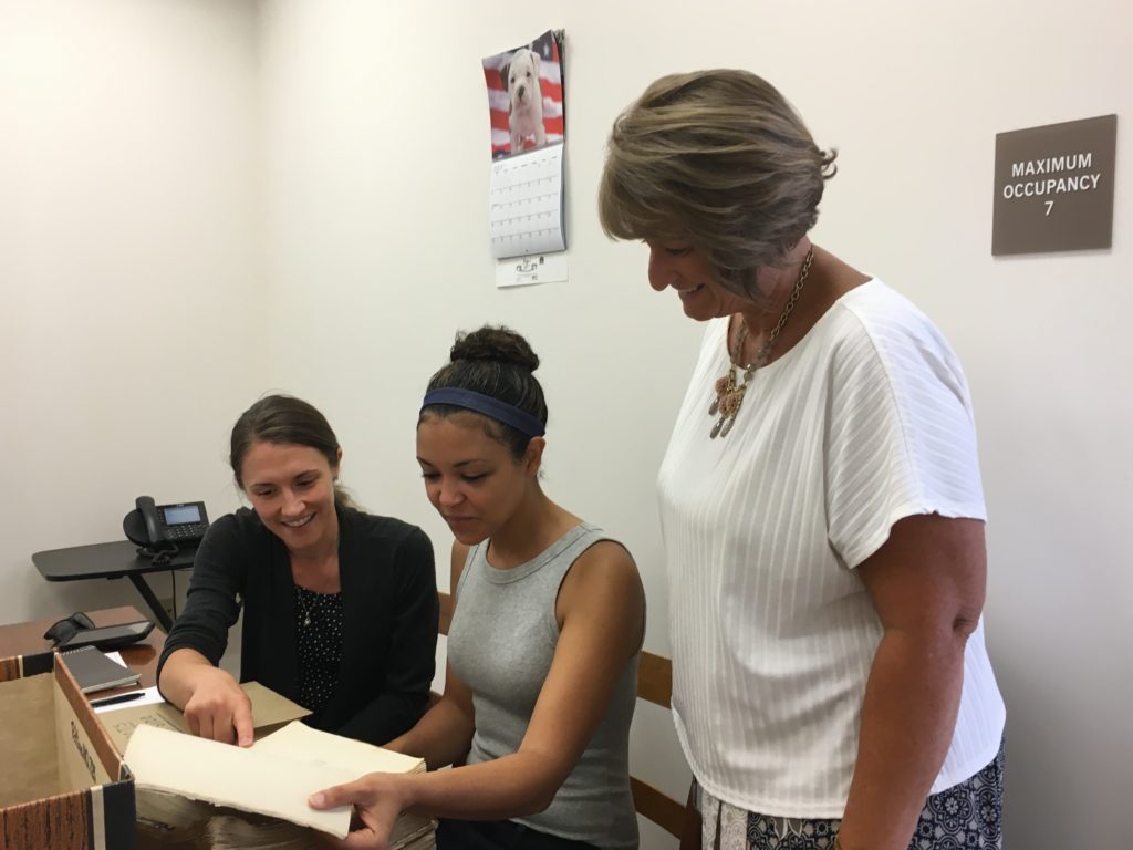 three women review a document