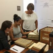 three women look over boxes of historic records