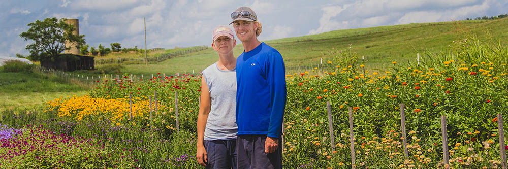 A man and woman stand on their farm.