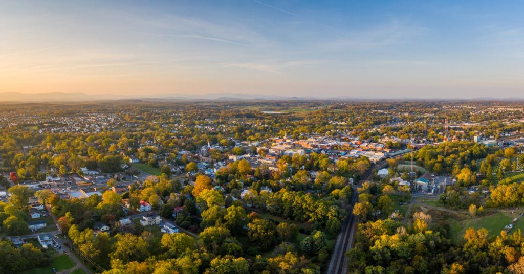 aerial photo trees, houses and buildings in culpeper with mountains in background