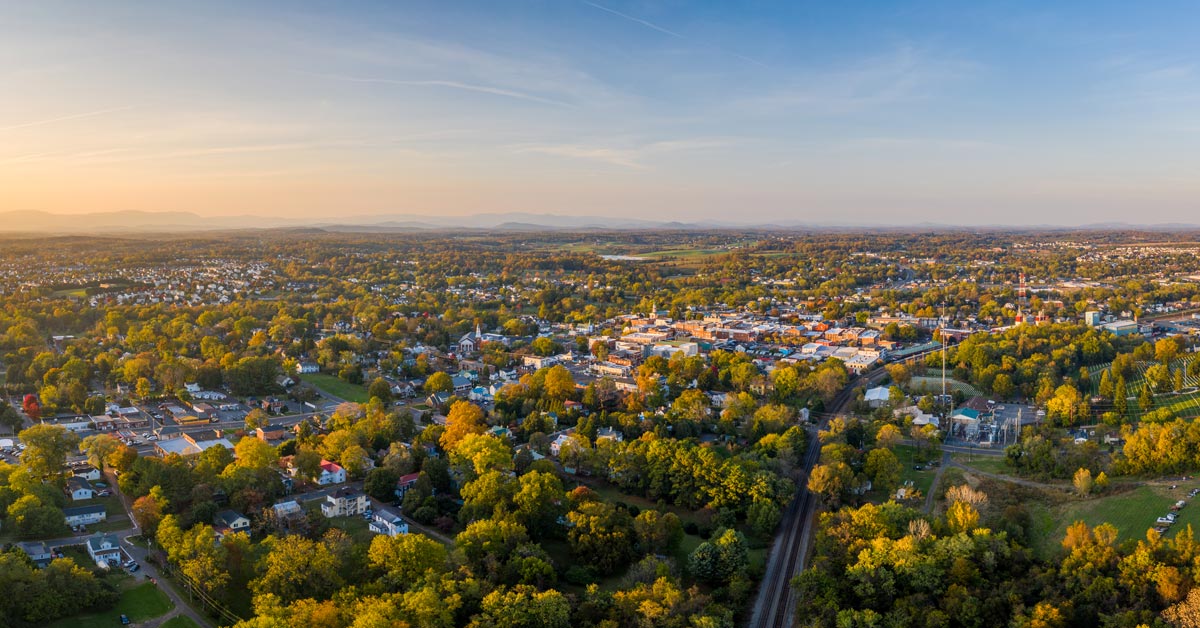 aerial photo trees, houses and buildings in culpeper with mountains in background
