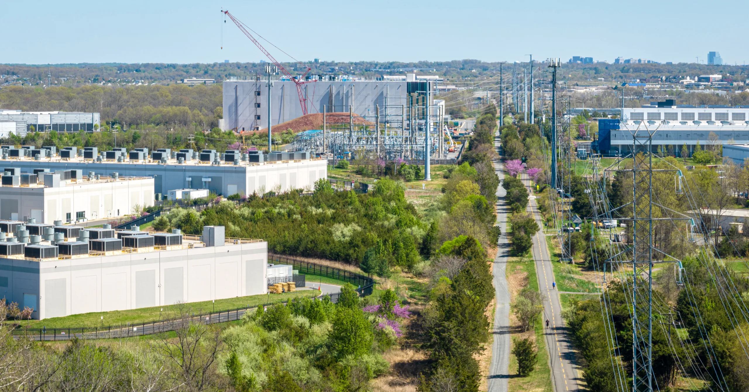 aerial photo looking out over 4 data center buildings and a transmission line running alongside a bike trail