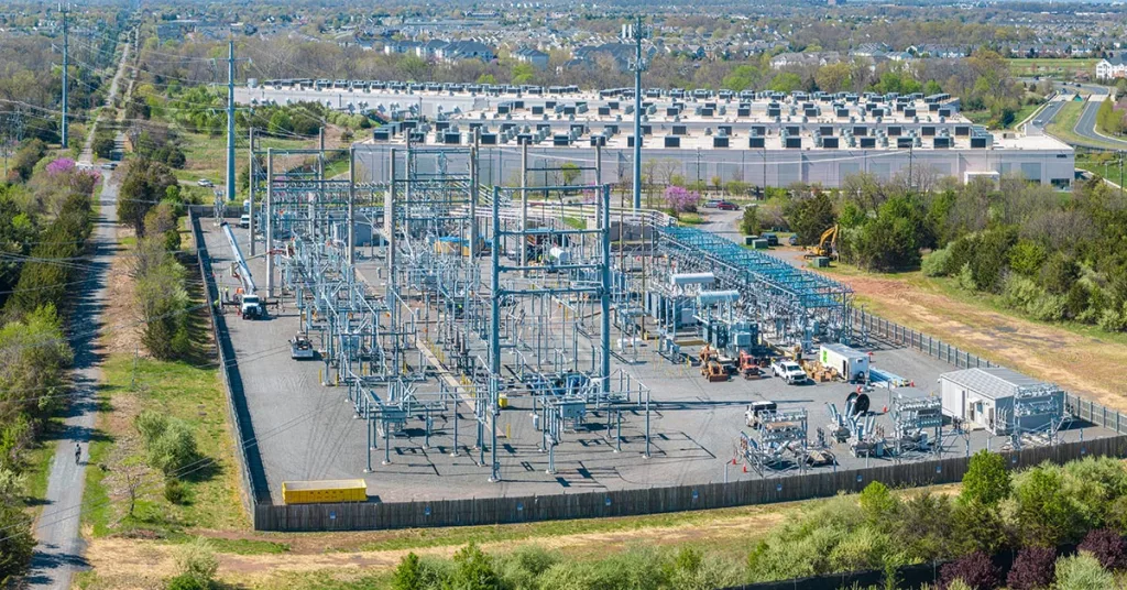 aerial view of electrical substation near a couple of huge data center buildings