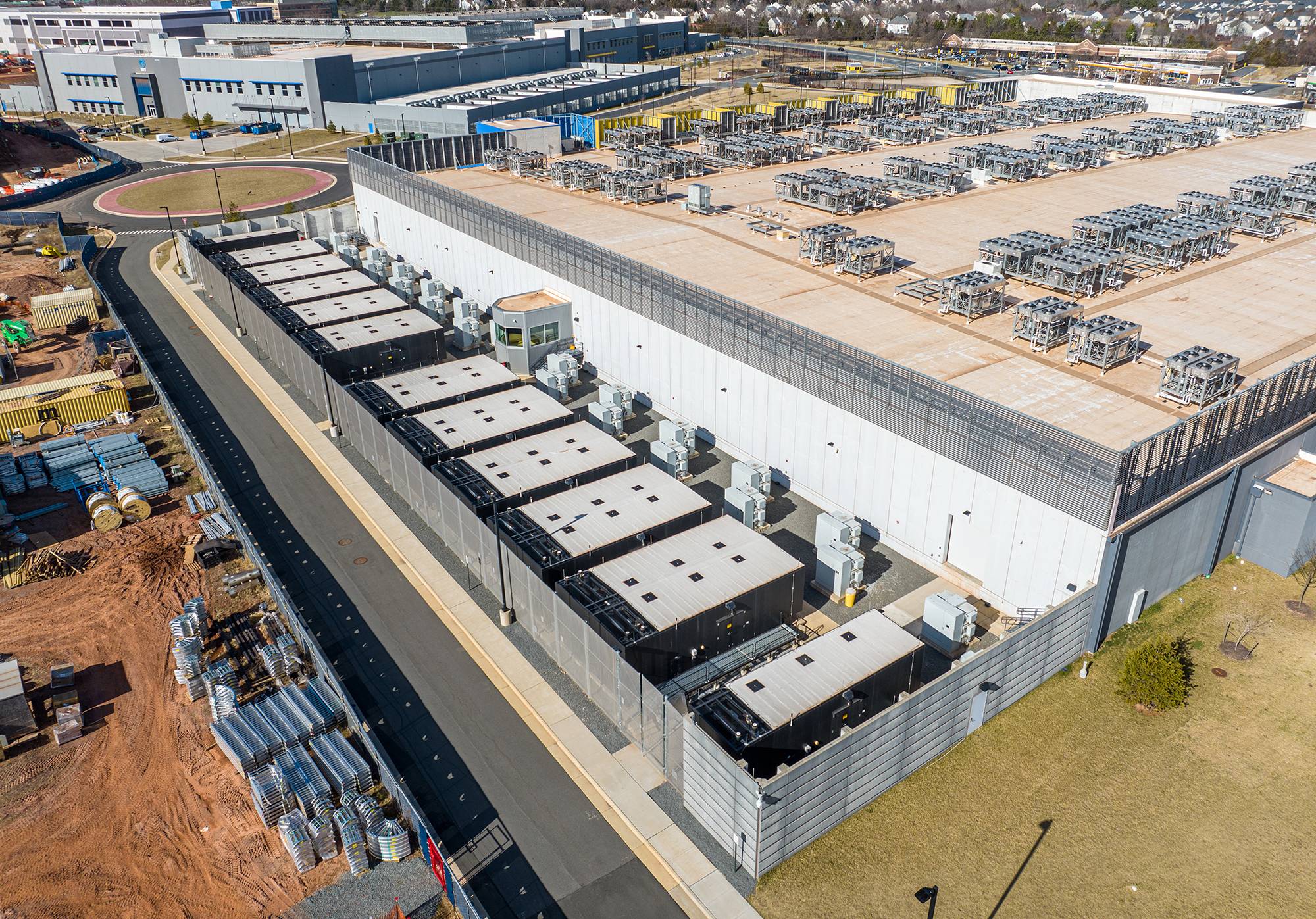 large box building with an adjacent row of 10+ rectangle diesel generators