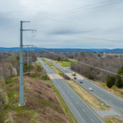 a transmission line looms over traffic
