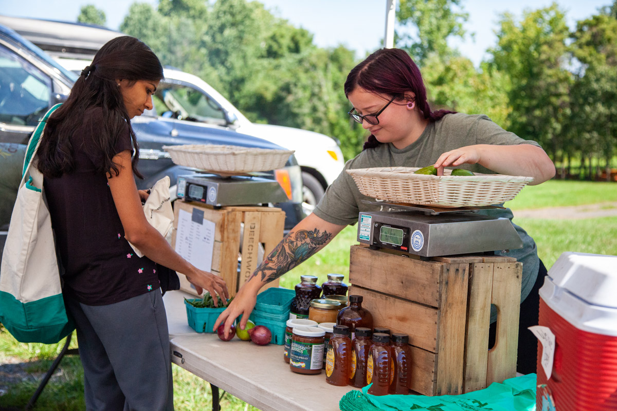 Person weighing produce at farmers market.
