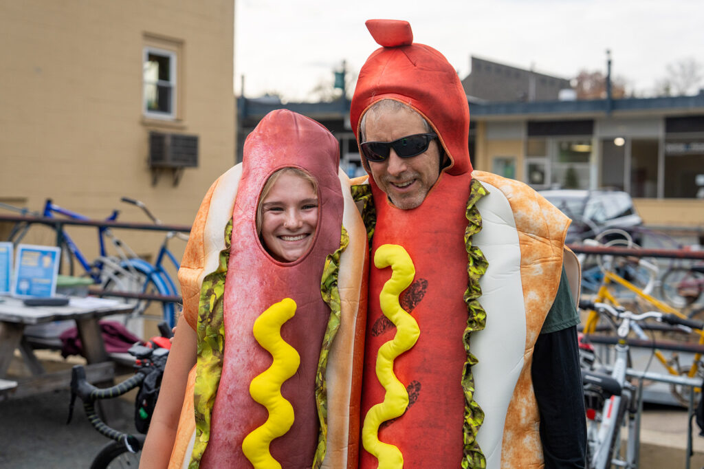 Peter Krebs of the Piedmont Environmental Council poses with a volunteer (both in hotdog costumes) in front of bicycles at the 2025 Halloween Bike Ride.