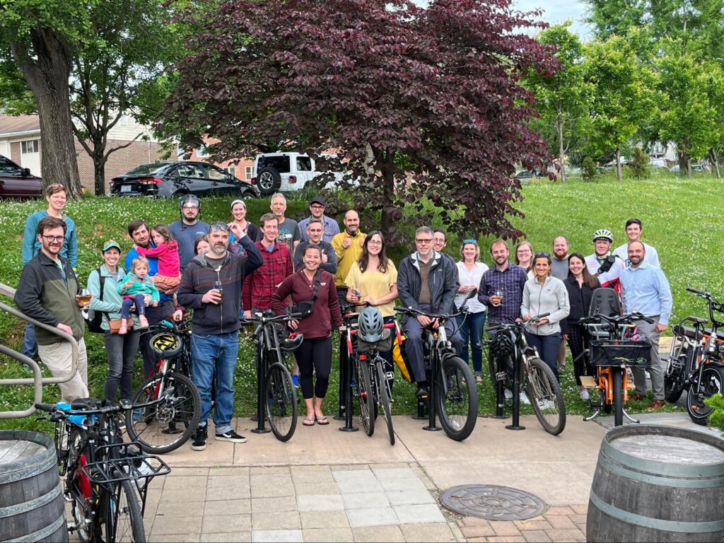 group of 25 people smile at with bikes