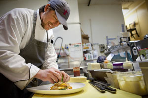 A chef plates a dish.