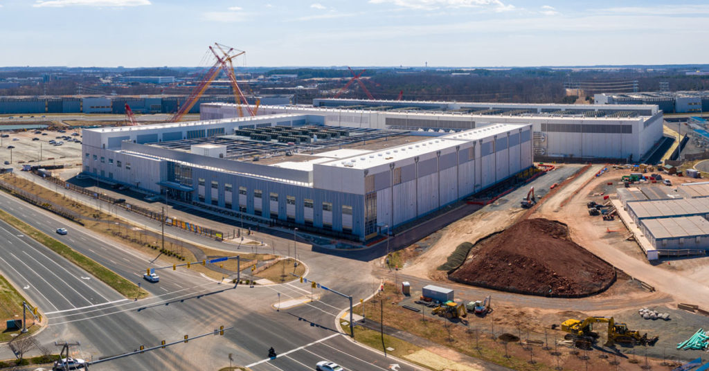 aerial view of a huge boxy building next to a 6 lane road