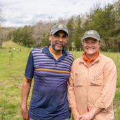 a man and woman stand side beside on a farm property