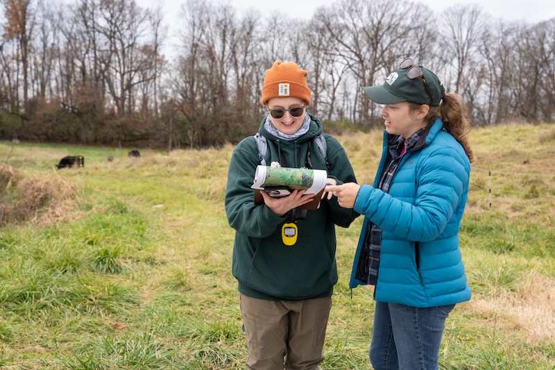 Two people reviewing a map outdoors.