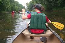A woman paddles a boat.