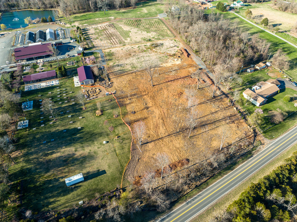 aerial image of a graded cemetery area along a rural road