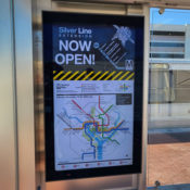 sign kiosk with map of metro system and grand opening announcement