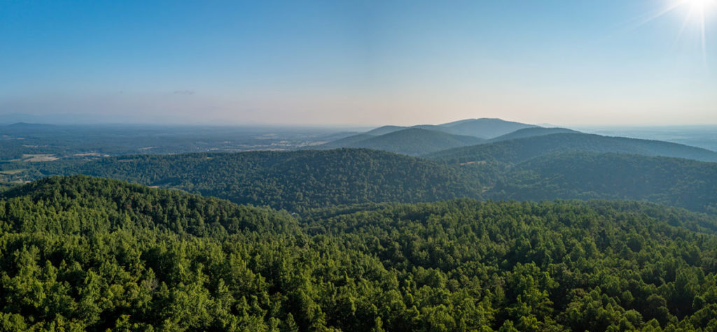 aerial view of green forested mountains stretching into the distance