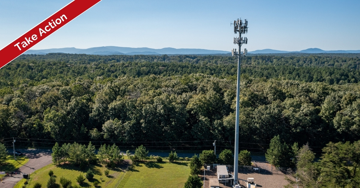 photo of cell tower with forests and mountains in background