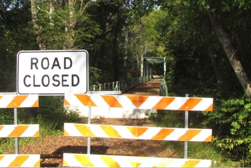A road with a "road closed" warning sign.
