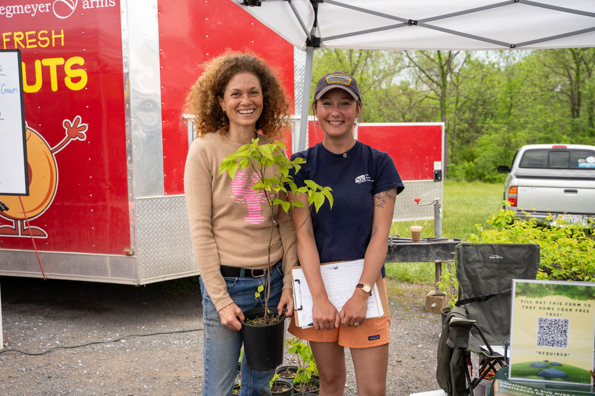 two women holding a small potted tree