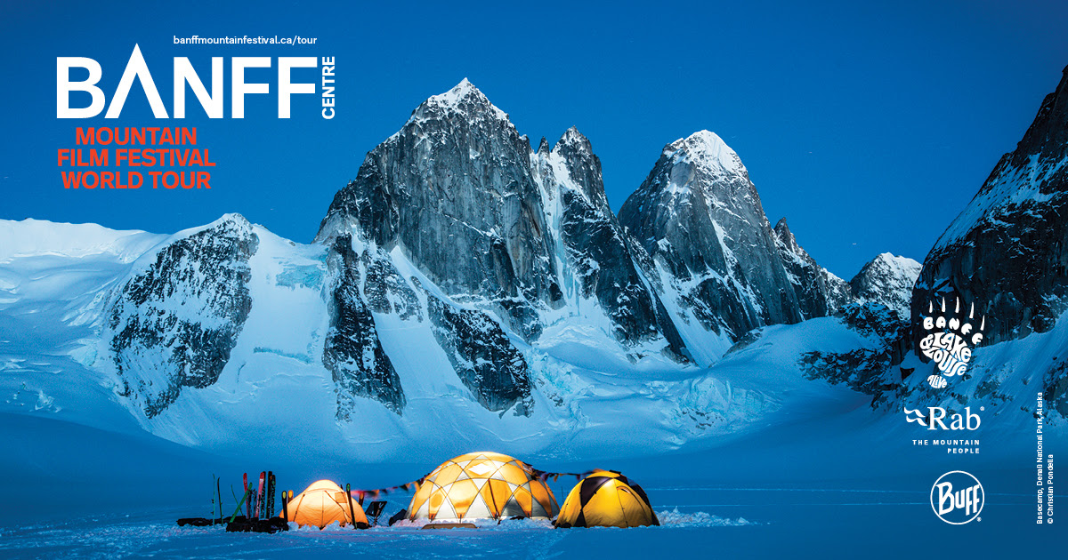 film festival poster of lit-up tents under a snowy mountain vista