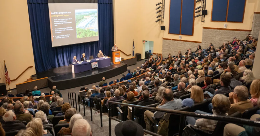 crowded auditorium of people watching a presentation on a screen