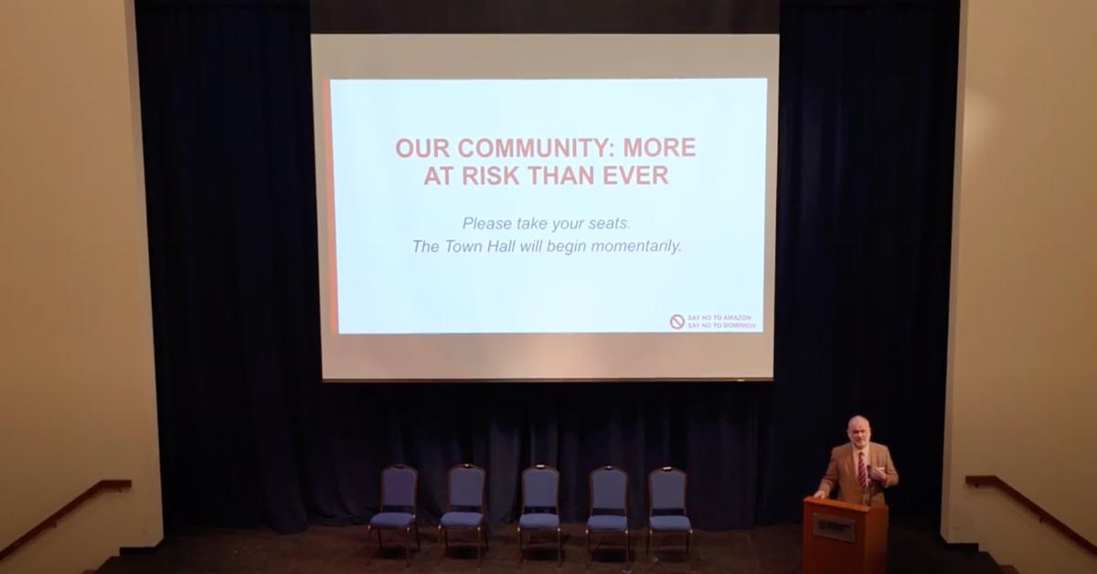 speaker on stage in front of projector screen