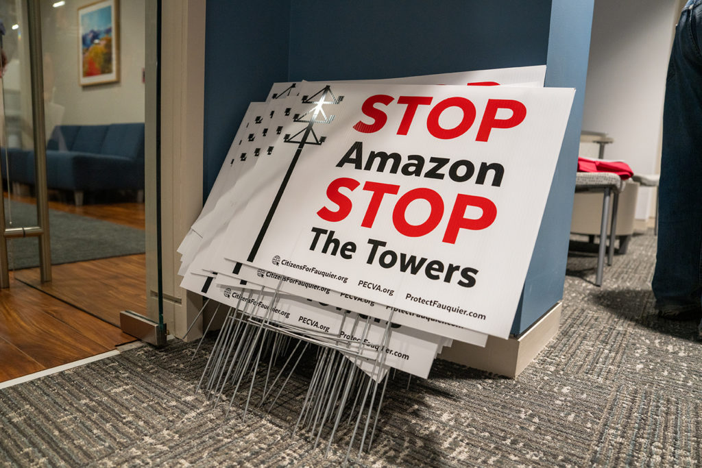signs that say "Stop Amazon, Stop the Towers"