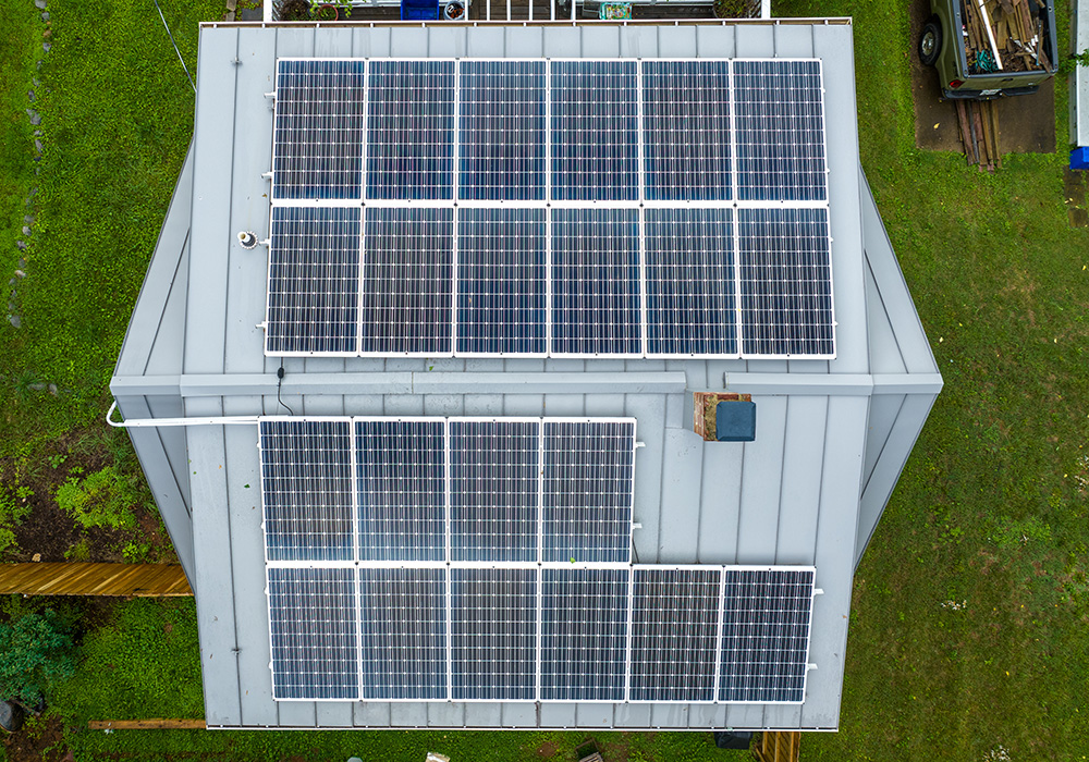 Aerial view of rows of solar panels on a home rooftop.