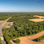 aerial image of forested land next to a major road